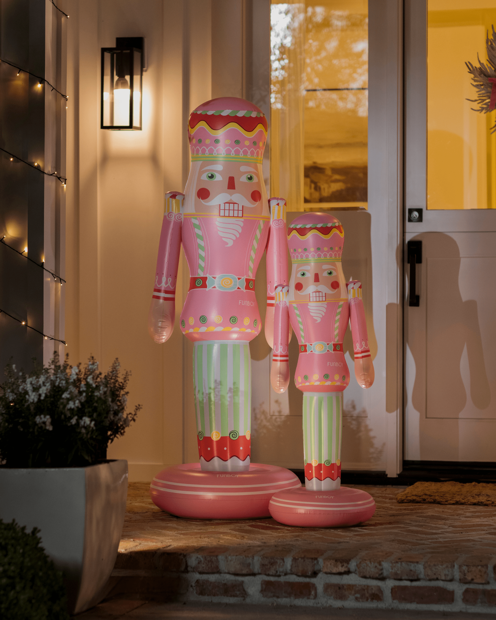 Decorative inflatable nutcrackers on a doorstep with a house in the background