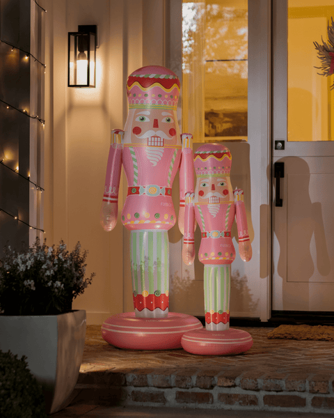 Decorative inflatable nutcrackers on a doorstep with a house in the background