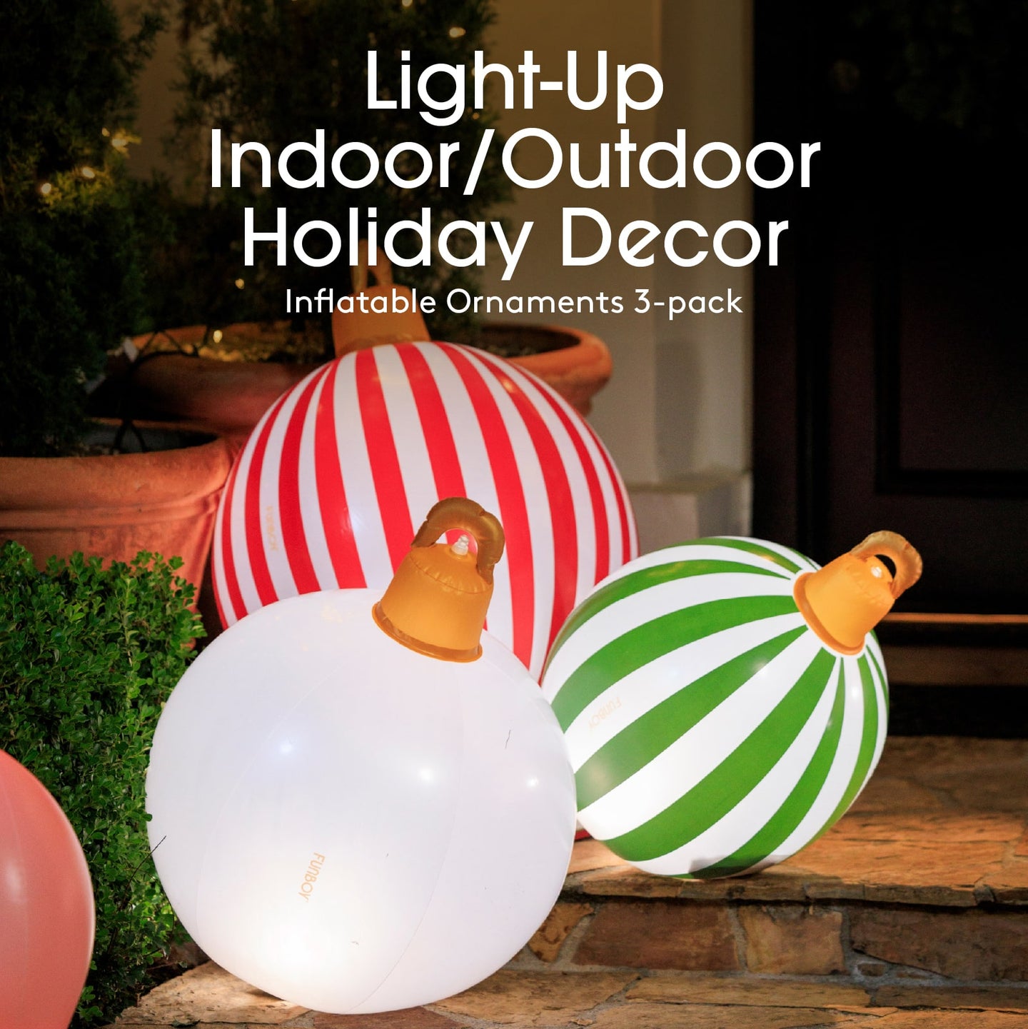 Inflatable holiday ornaments in red, white, green, and orange on a wooden surface outdoors.