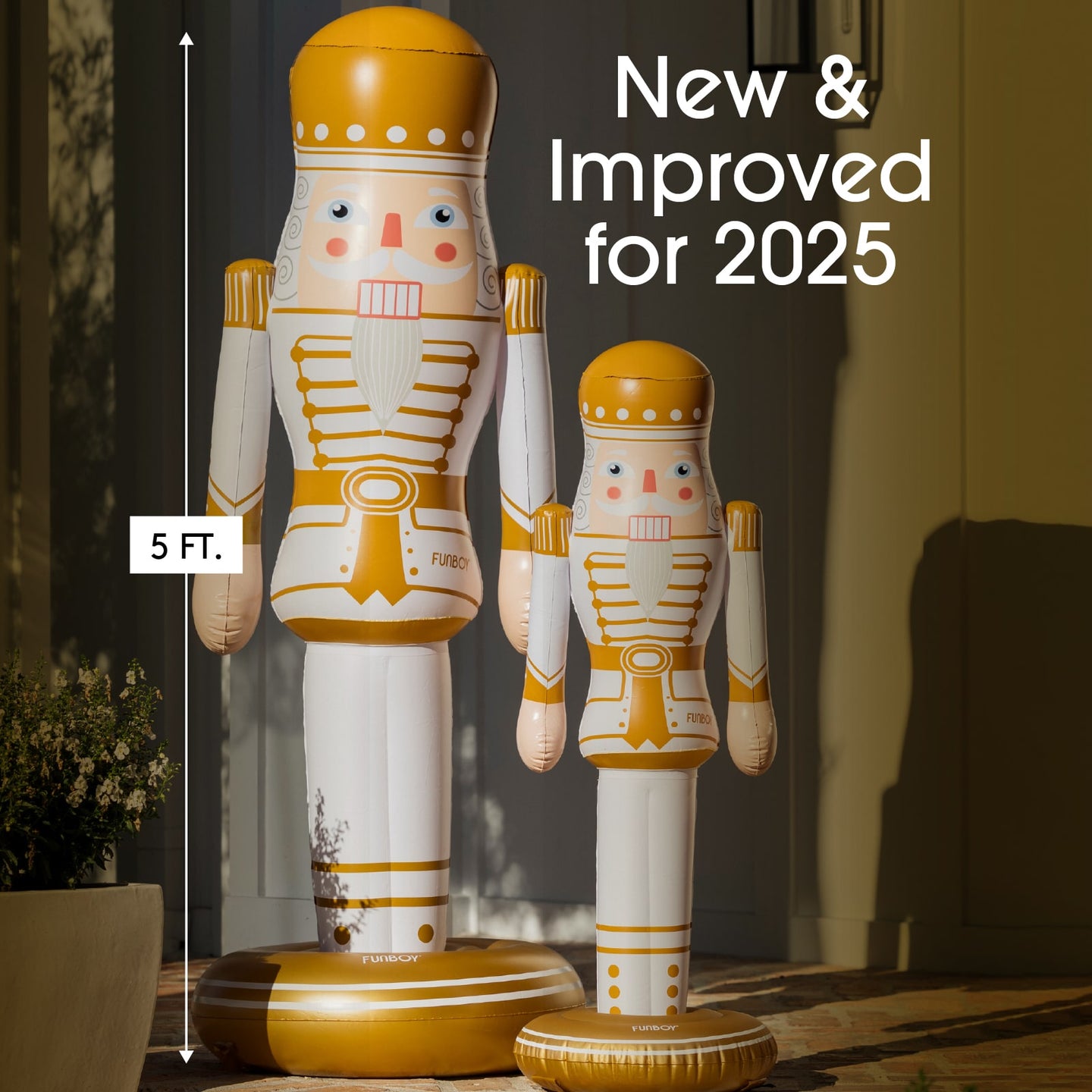 Two large nutcrackers with gold and white design, standing on a surface indoors.