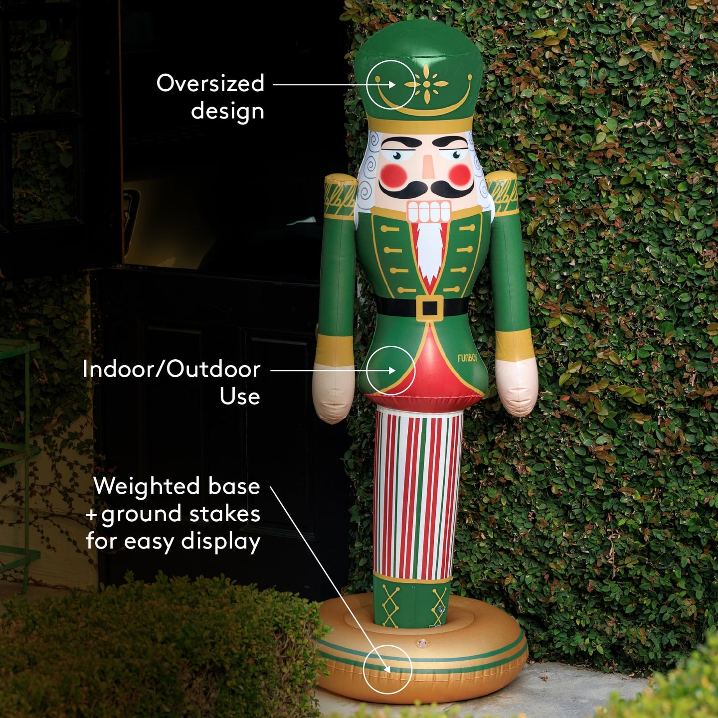 Decorative inflatable nutcracker with features highlighted, standing against a hedge.