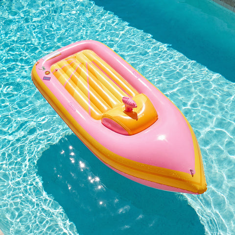 Pink and yellow inflatable Barbie boat pool float  in clear blue water