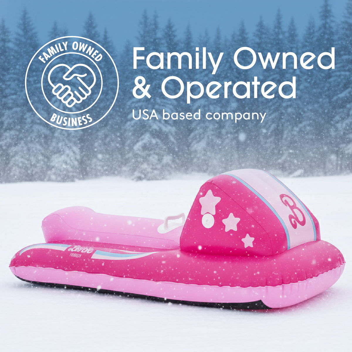 A pink inflatable snowmobile slide toy placed in a snowy outdoor scene with pine trees in the background. White text at the top reads 'Family Owned & Operated' and 'USA based company,' with a circular 'Family Owned Business' logo on the left.