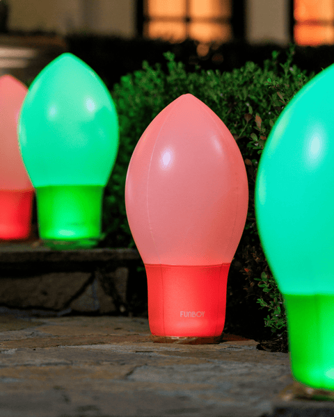Colorful light bulb-shaped lamps on a stone surface with a blurred natural background