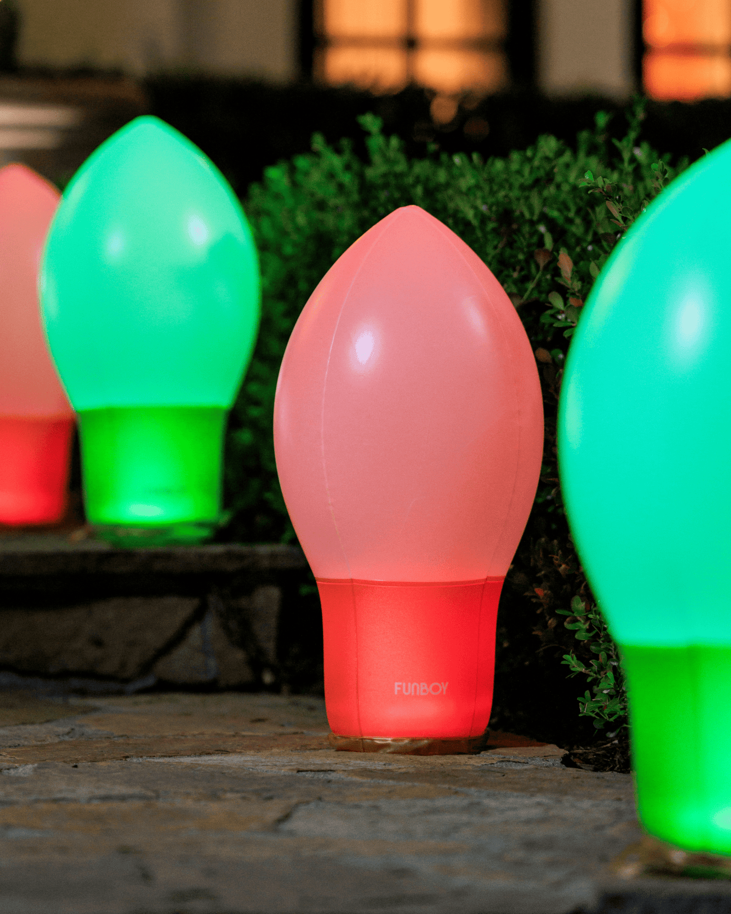 Colorful light bulb-shaped lamps on a stone surface with a blurred natural background