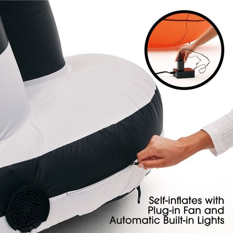 A partially inflated black and white inflatable chair or lounge piece shown on a white background, with a hand unzipping the side. A circular inset shows a hand plugging an electric pump, and text reads 'Self-inflates with Plug-in Fan and Automatic Built-in Lights.