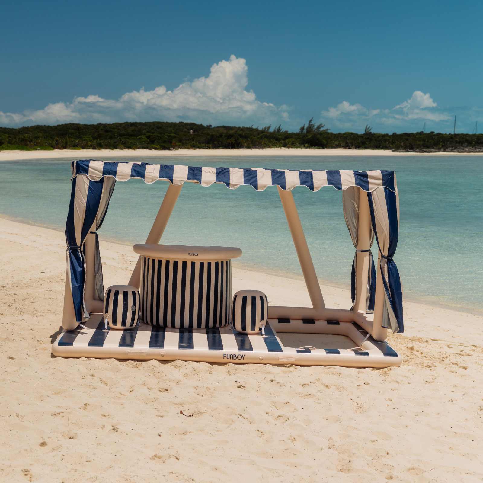 FUNBOY VIP island canopy and table on a sandy beach with ocean and sky in the background