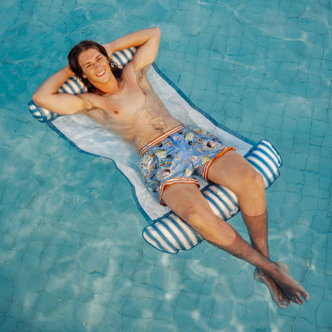 man lying on a blue and white striped pool hammock float with mesh