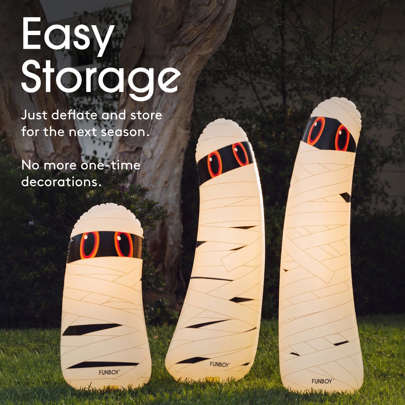Three mummy-shaped outdoor LED light lamps in different sizes standing on grass in front of a tree, with text reading 'Easy Storage' and 'Just deflate and store for the next season. No more one-time decorations.