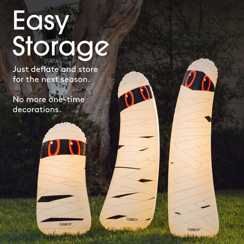 Three mummy-shaped outdoor LED light lamps in different sizes standing on grass in front of a tree, with text reading 'Easy Storage' and 'Just deflate and store for the next season. No more one-time decorations.