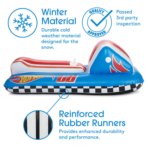Inflatable snowmobile-style ride toy shown on a white background with marketing text and callout graphics. The product is blue with red and white sections, a black-and-white checkered side strip, flame graphics, and a small Hot Wheels logo.