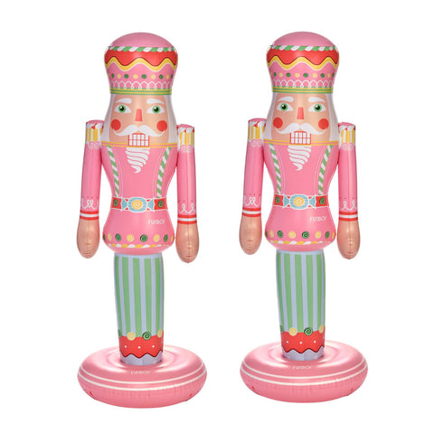 Two pink nutcracker-shaped inflatables on a white background, each with green striped legs and colorful decorative details.