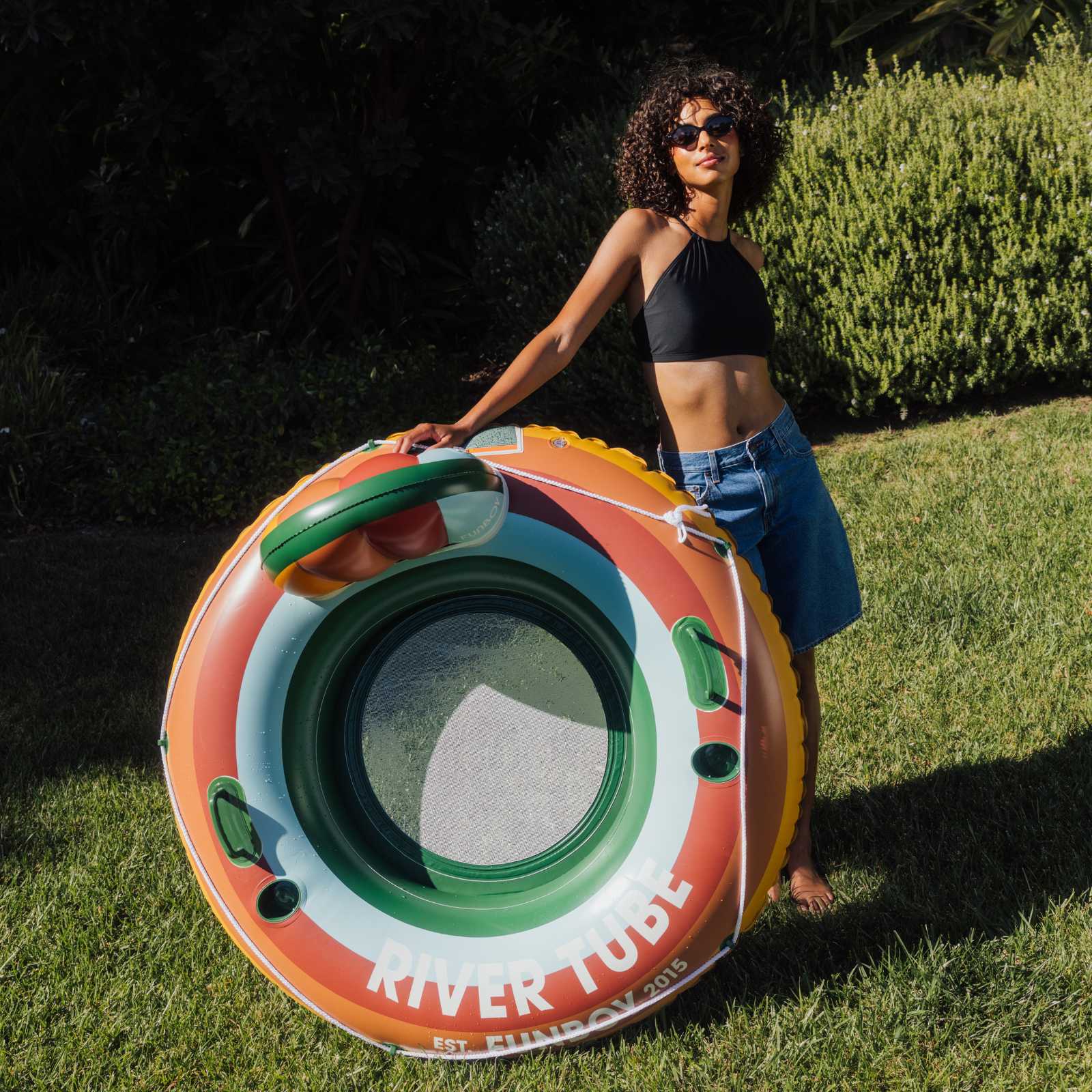 Woman holding a colorful inflatable tube on grass