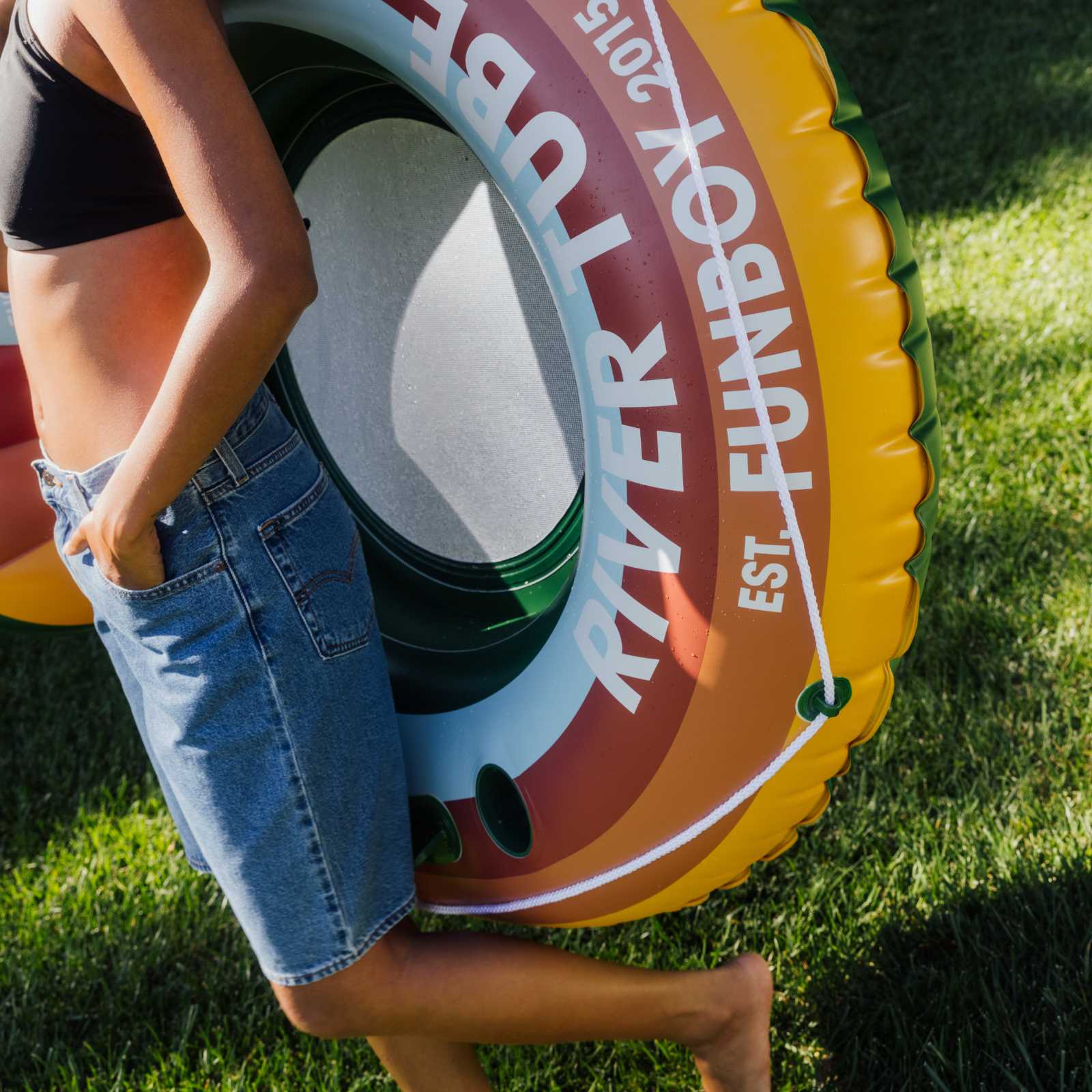 Person holding a River Town Funbox inflatable ring on grass