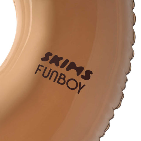 Close-up of a brown product with 'SKIMS FUNBOY' text on a white background
