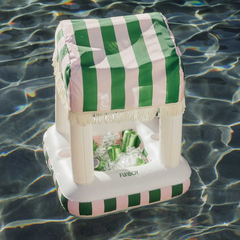 Inflatable cooler with green and white striped cover floating on water