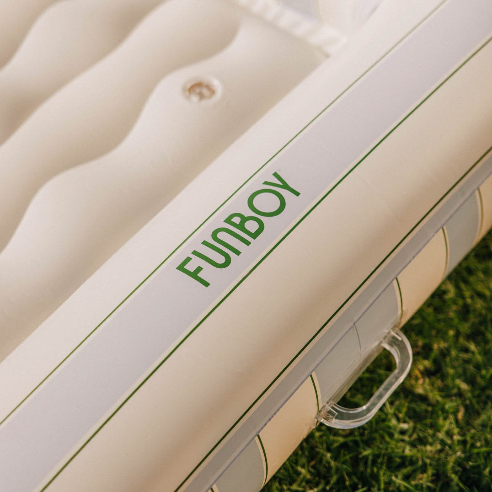 Inflatable pool float with 'Funboy' branding on a grassy background