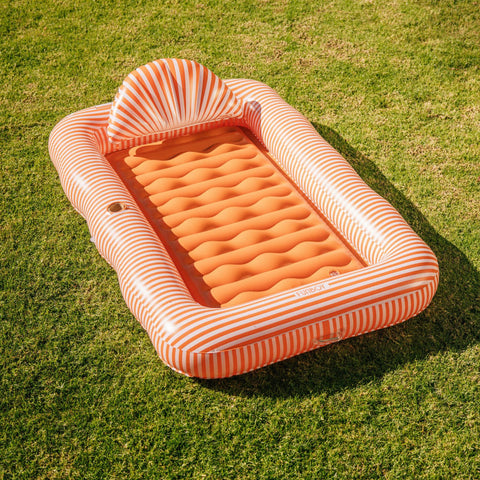 Inflatable pool toy with striped border on grass