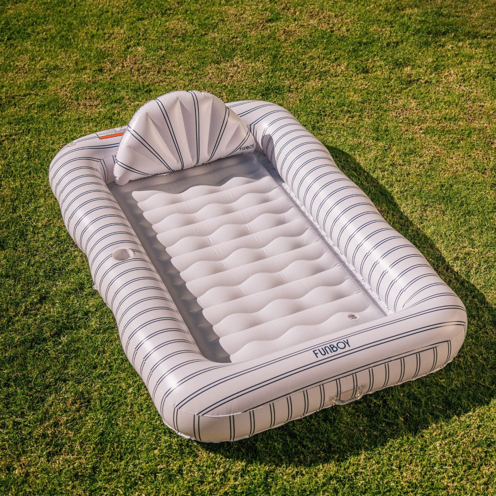 Inflatable pool with striped design on a grassy background