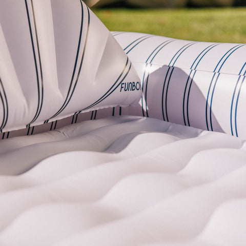 Inflatable pool float with striped pattern on a grassy background